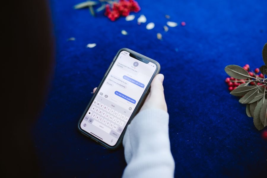 Hand holding a smartphone showing text message notifications